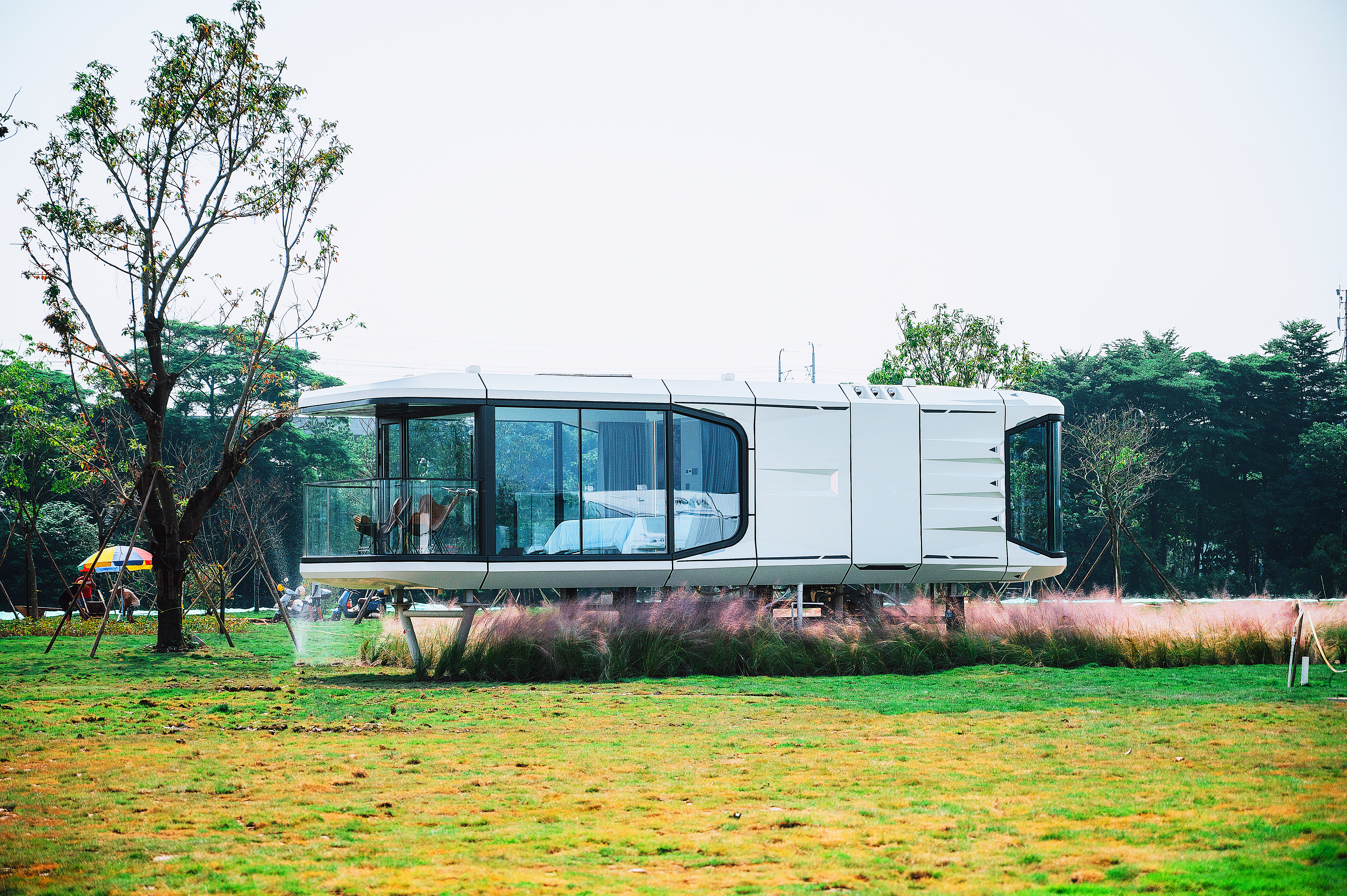 G70 capsule accommodation with panoramic windows in a landscaped setting